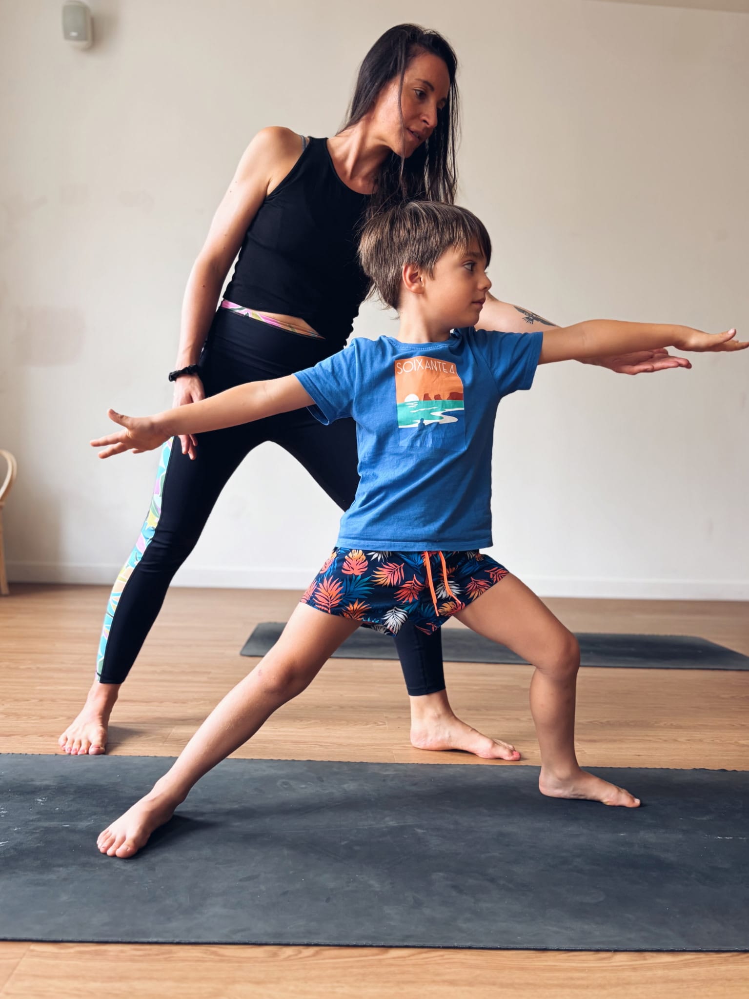 Typhaine accompagne un enfant dans une posture de yoga